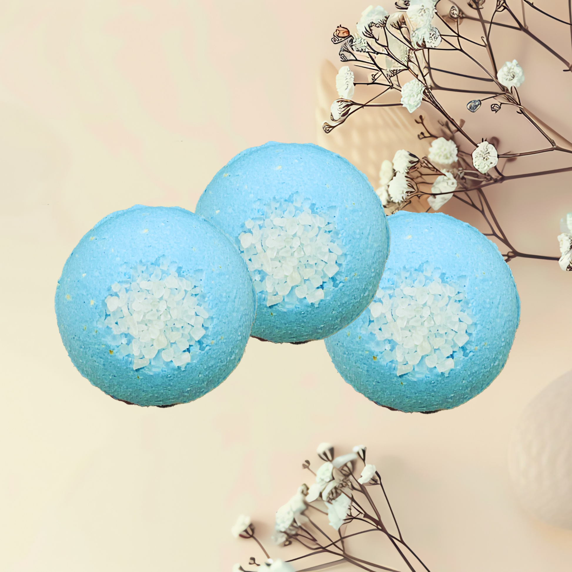 Three blue bath bombs with sea salt on a beige background with dried flowers.