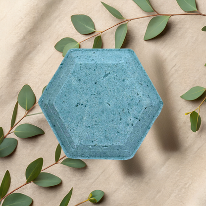 Hexagonal blue steamer on a beige fabric background with green leaves