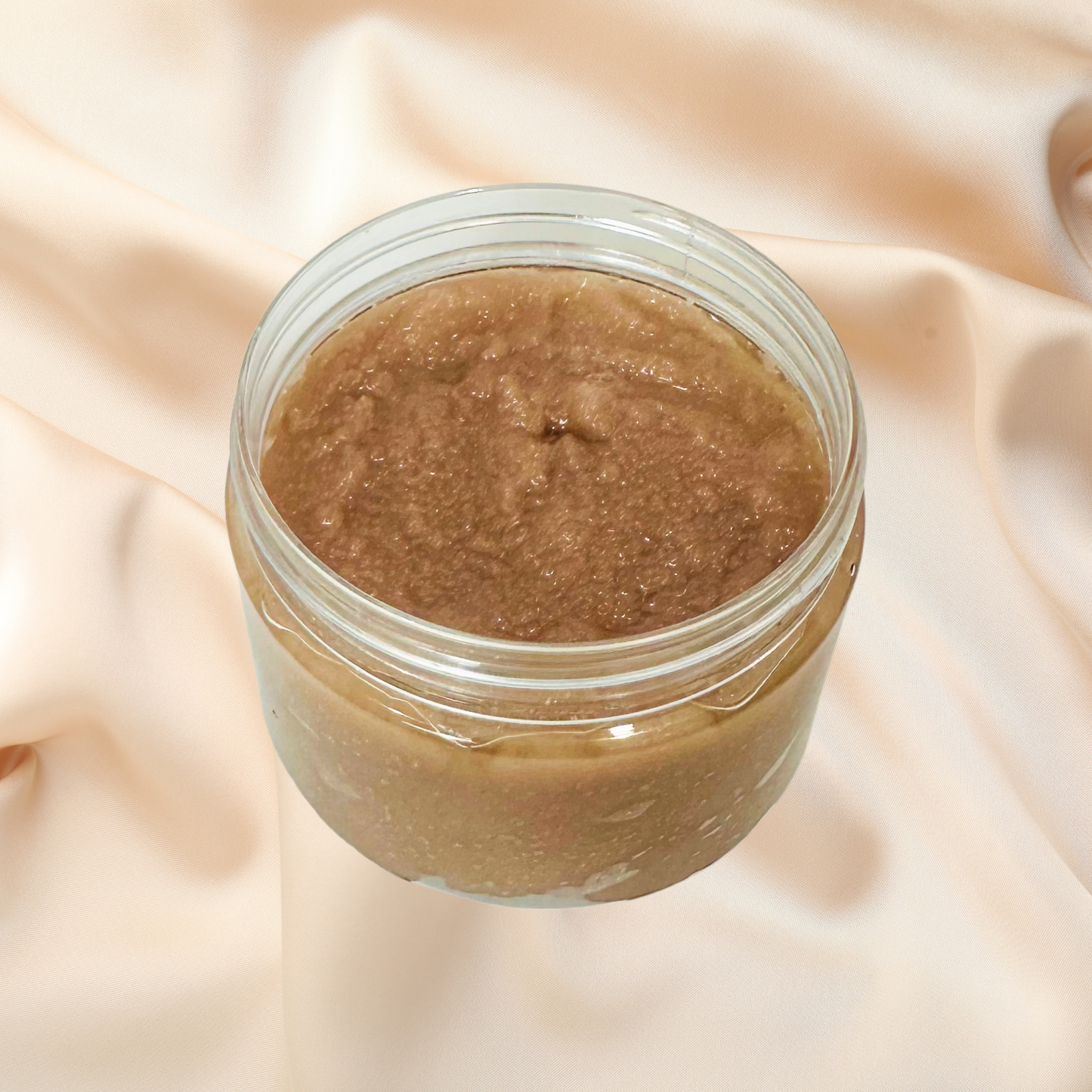 Jar of brown scrub on a beige fabric background