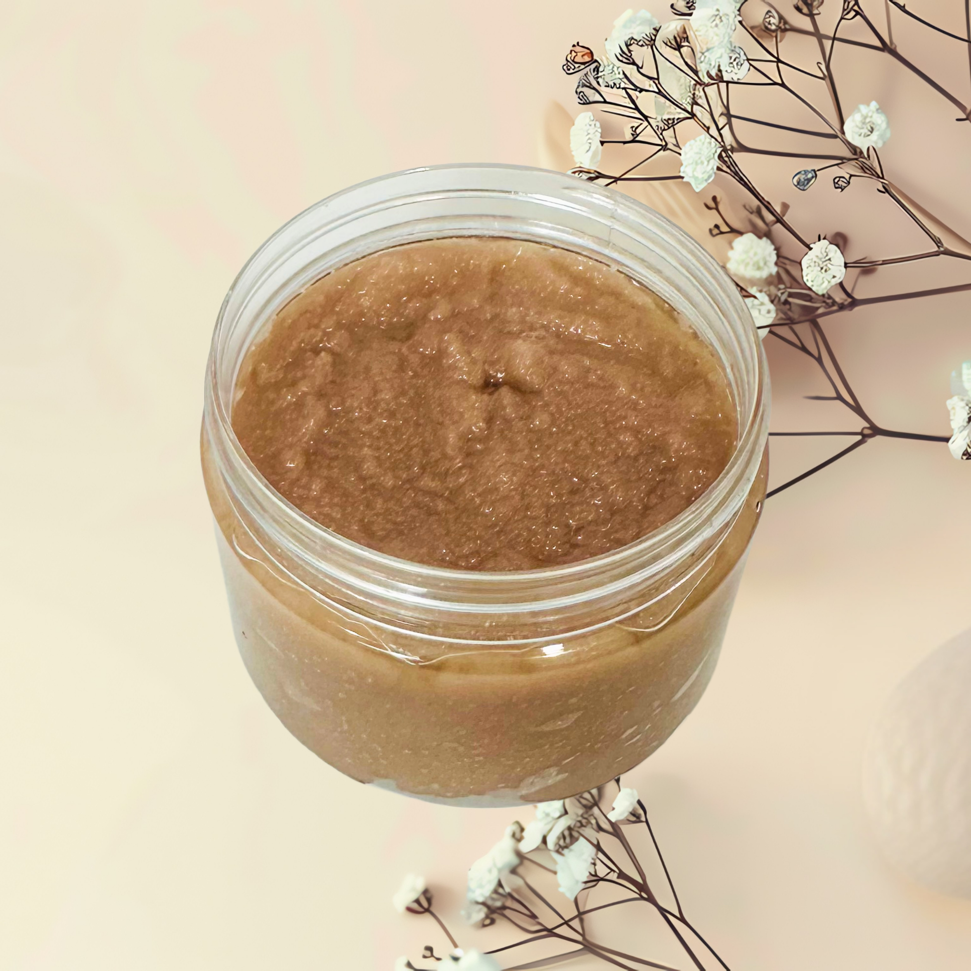 Jar of brown scrub with white flowers on a light pink background