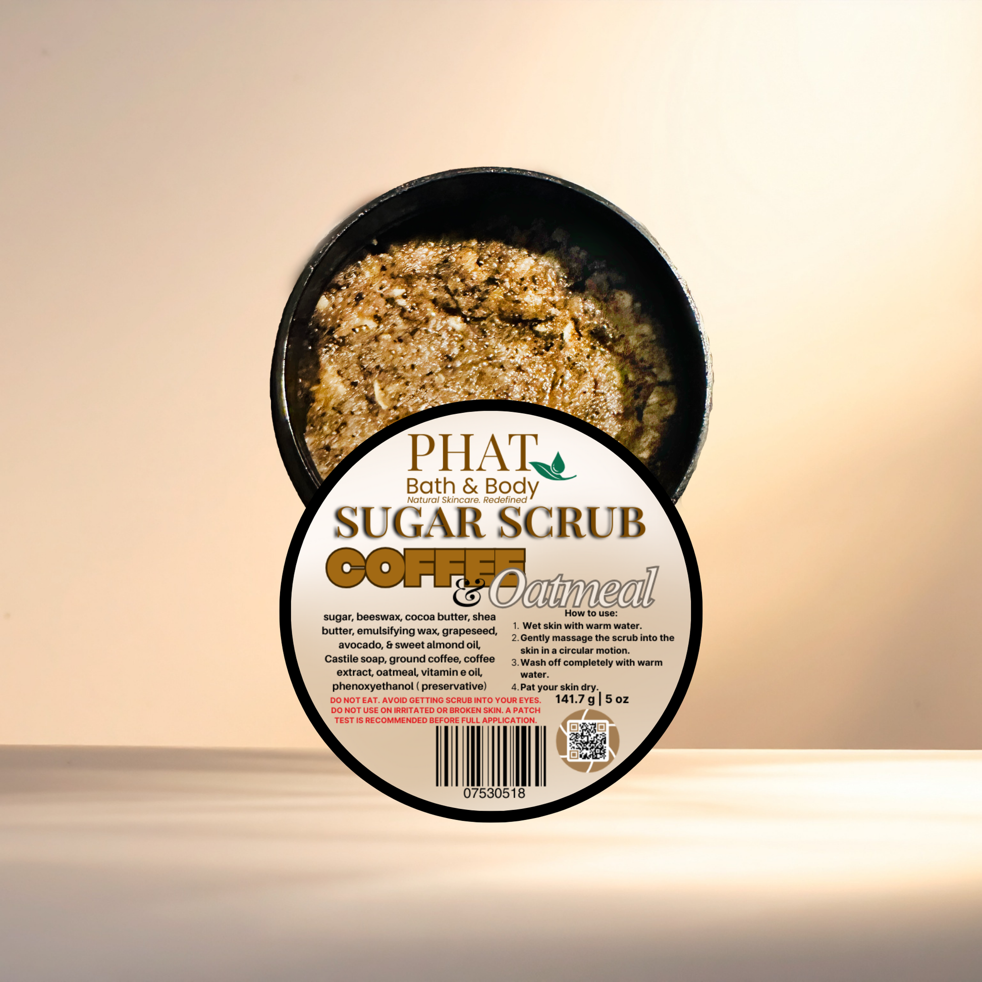 Container of Phat Bath & Body coffee and oatmeal sugar scrub on a beige background