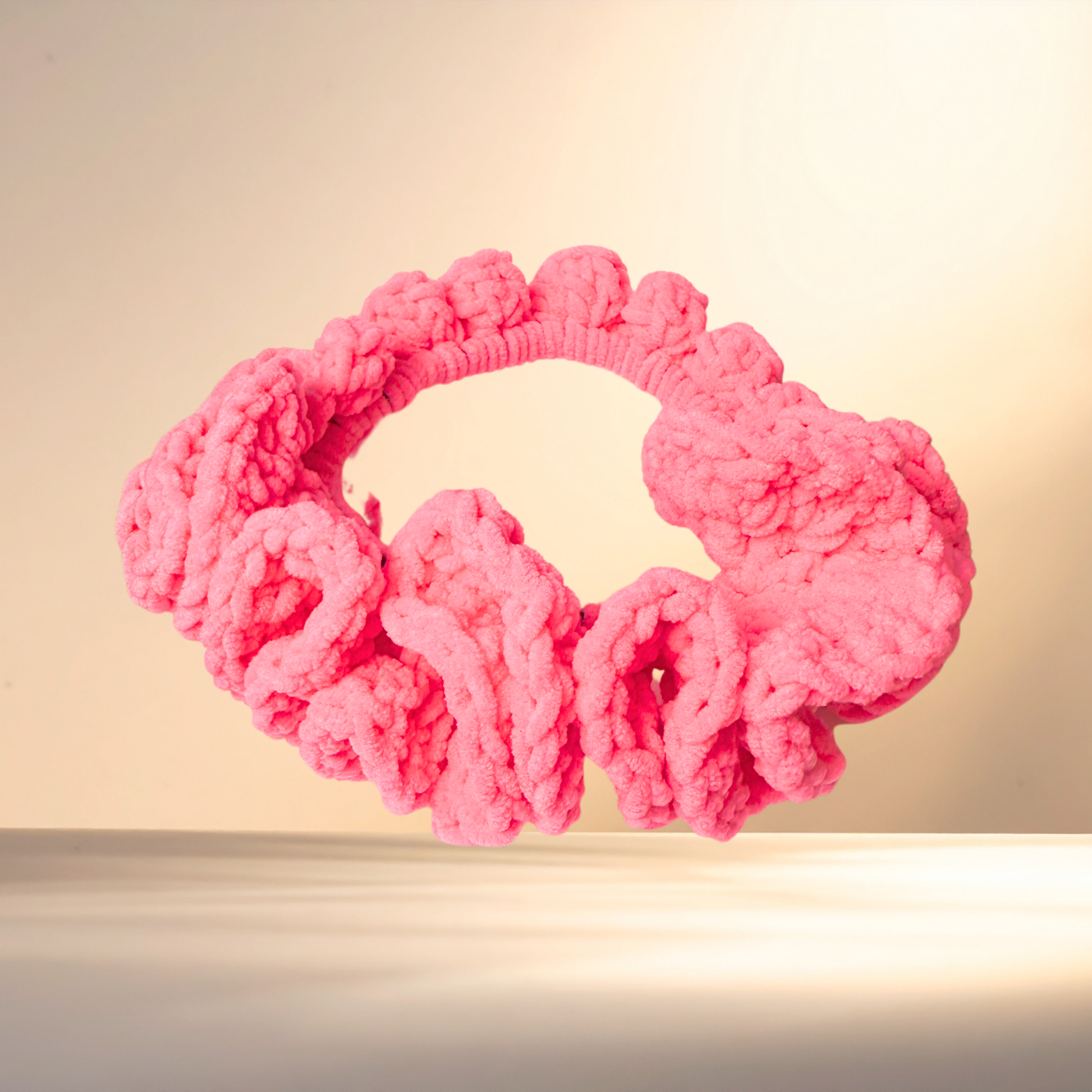 Pink knitted headband on a light background