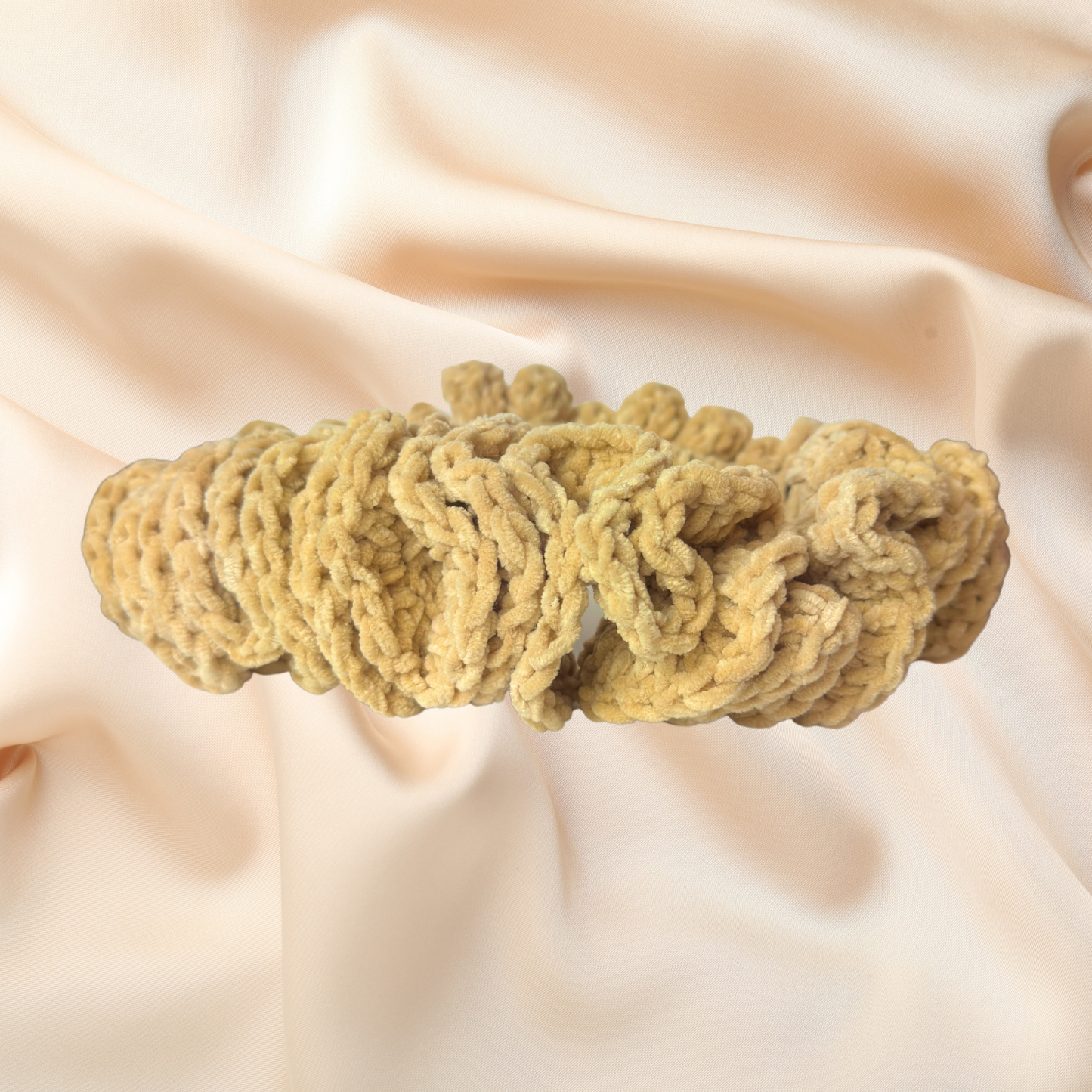 Beige knitted headband on a soft beige fabric background