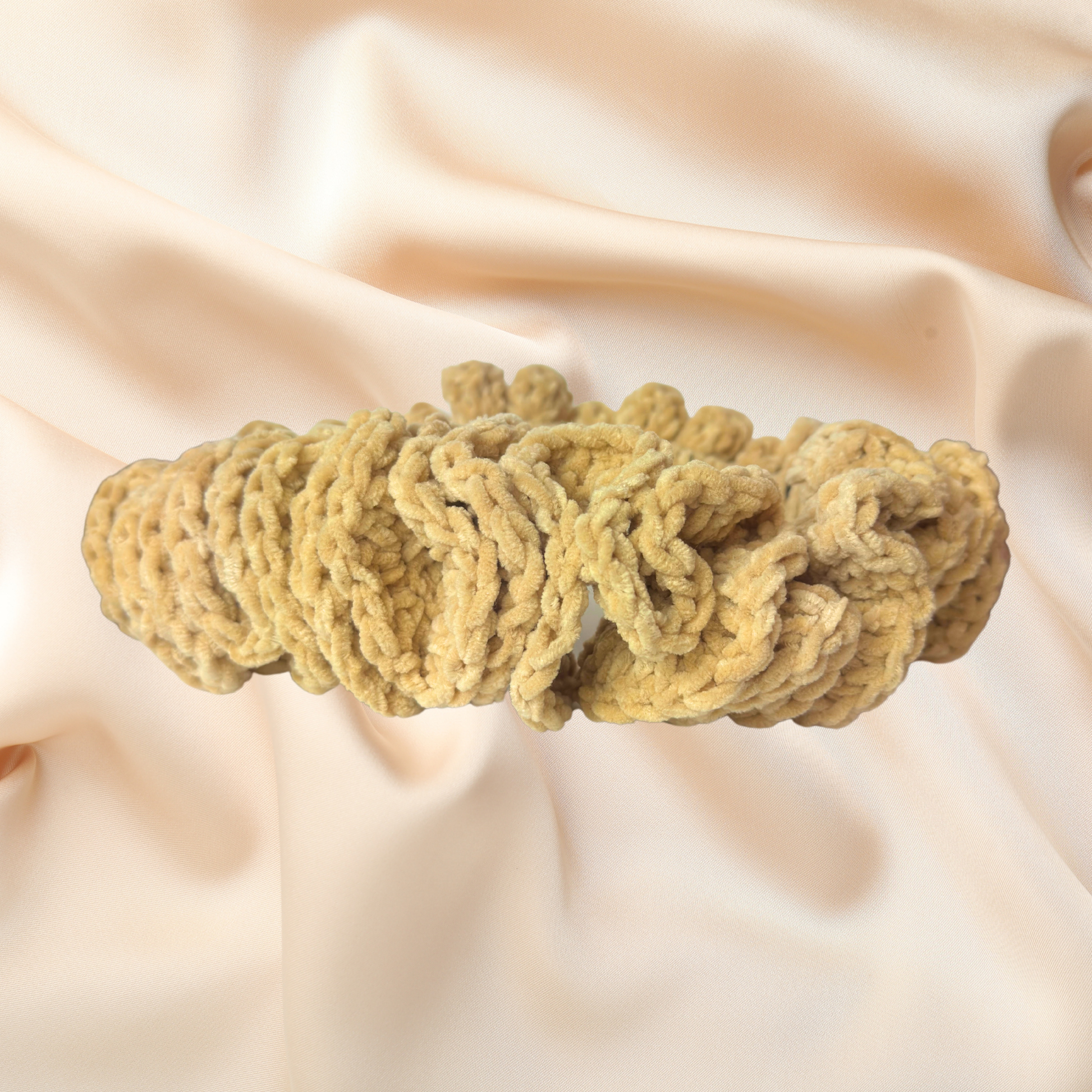 Beige knitted headband on a soft beige fabric background