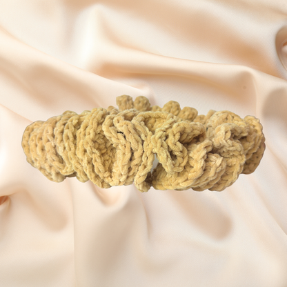 Beige knitted headband on a soft beige fabric background