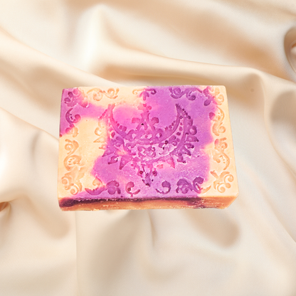 Decorative soap bar with intricate design on a soft fabric background
