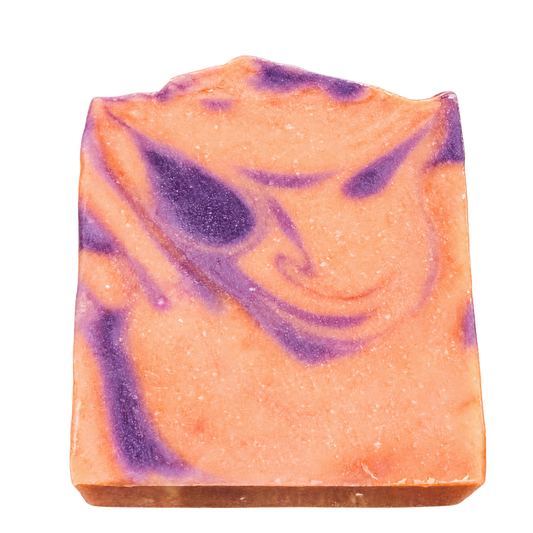 Cranberry Spice handmade bar soap by Phat Bath & Body featuring peach-orange coloring with purple swirls and a textured, uneven top.