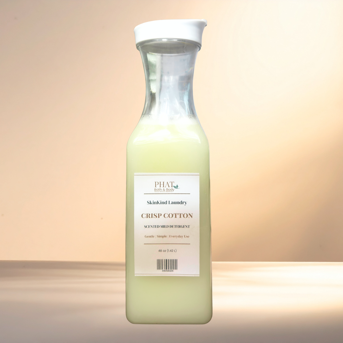 Bottle of Phat Bath & Body SkinKind Laundry Crisp Cotton detergent on a gradient background