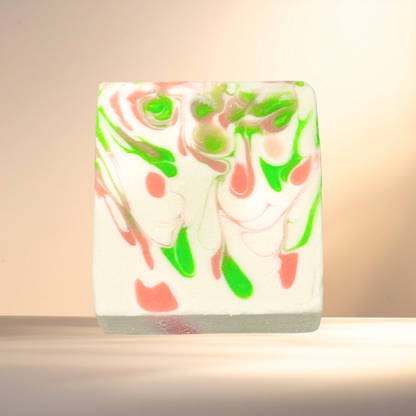 Marbled soap bar with green and pink swirls on a neutral background
