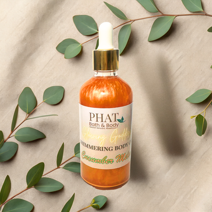 Bottle of 'PHAT Bath & Body' cucumber melon body oil on a beige fabric background with green leaves.