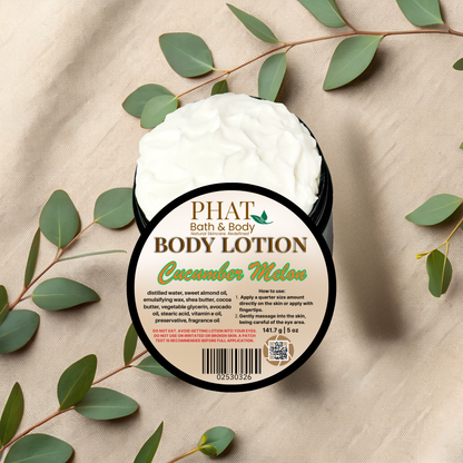 Body lotion container labeled 'PHAT Bath & Body' with cucumber melon scent on a beige fabric background with green leaves.