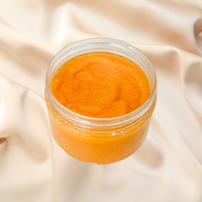 Jar of orange scrub on a beige fabric background