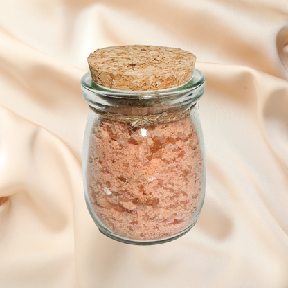 Glass jar with cork lid containing pink Himalayan salt on a beige fabric background