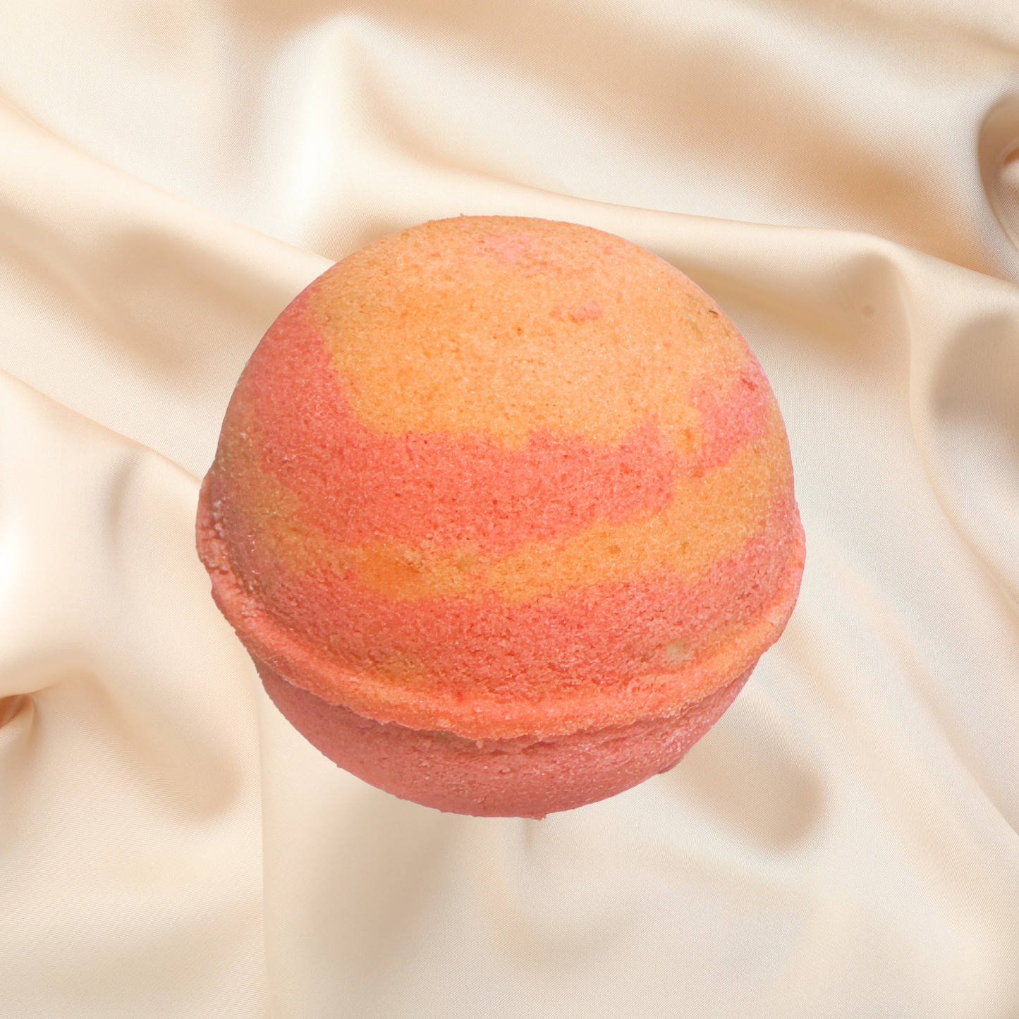 Orange bath bomb on a beige fabric background