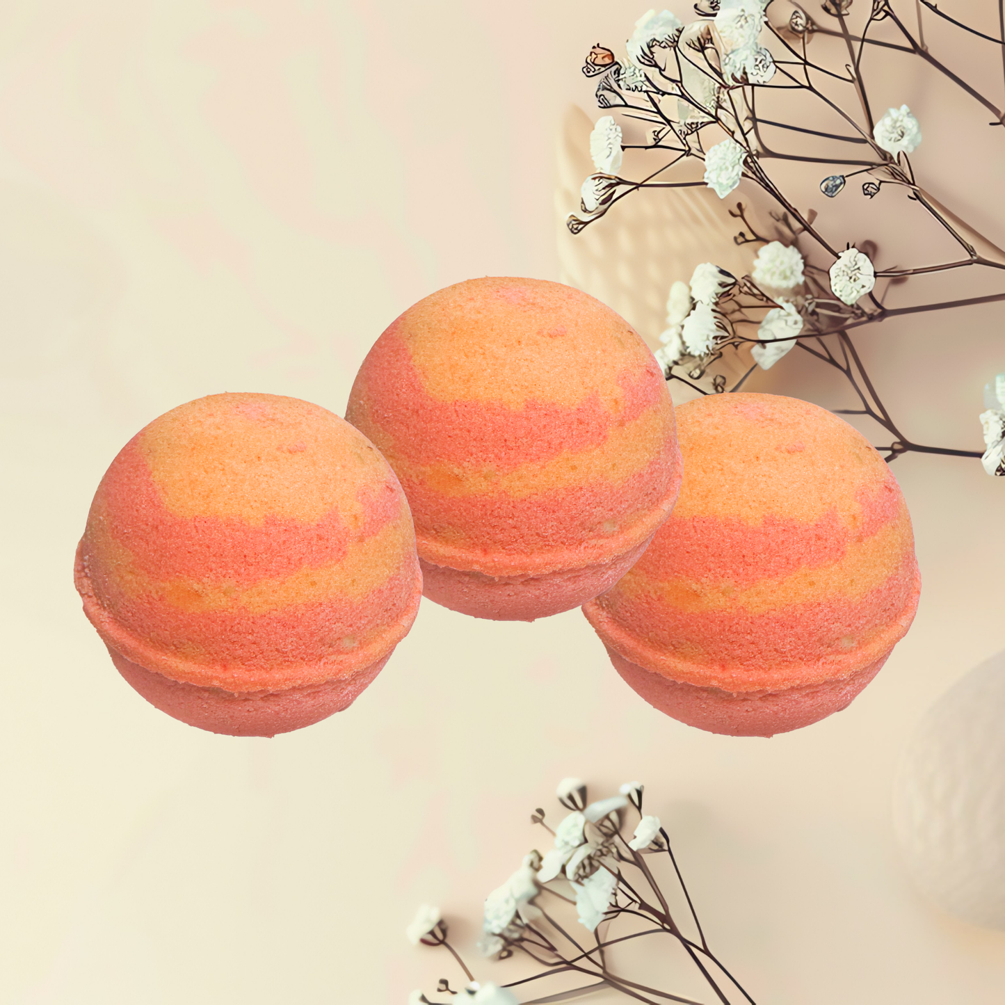 Three striped orange and pink bath bombs on a light beige background with white flowers.