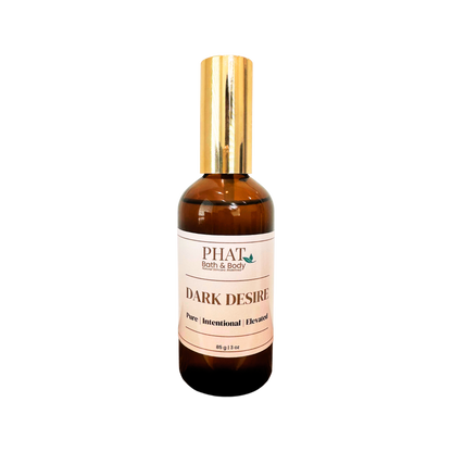 An amber glass bottle of PHAT Bath & Body 'Dark Desire' pure intentional elevated fragrance with a shiny gold cap, centered on a plain white background.