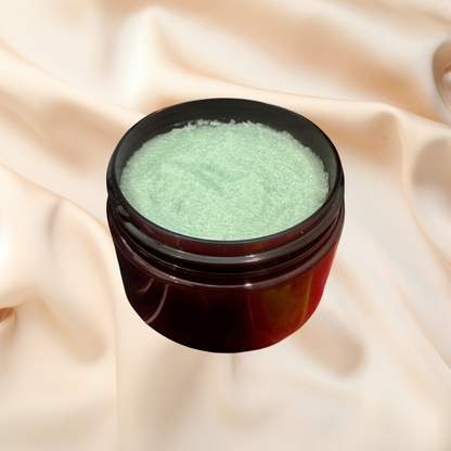 Open jar of green sugar scrub on a beige fabric background