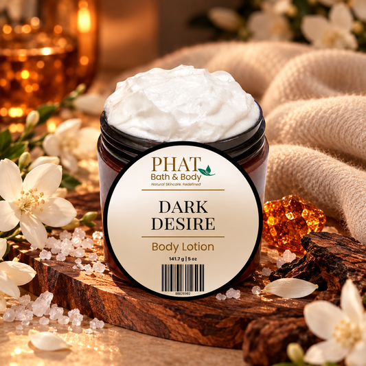 Phat Bath & Body Dark Desire 5 oz Body Lotion with labeled lid, styled with white florals, sea salt, warm woods, amber accents, and soft cashmere-like fabric.