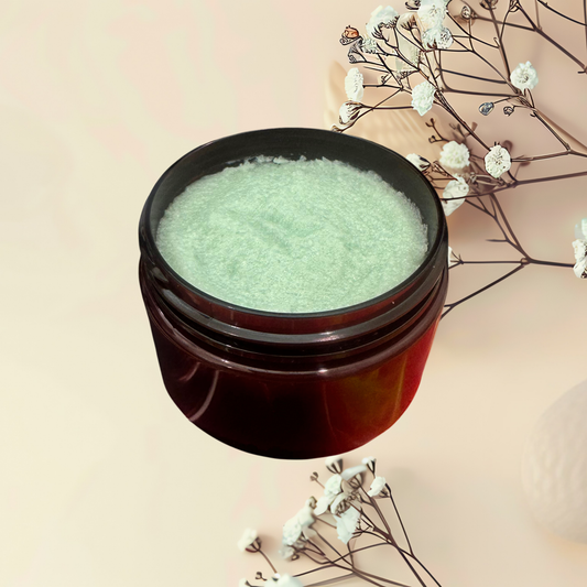 Jar of green sugar scrub with white flowers on a beige background