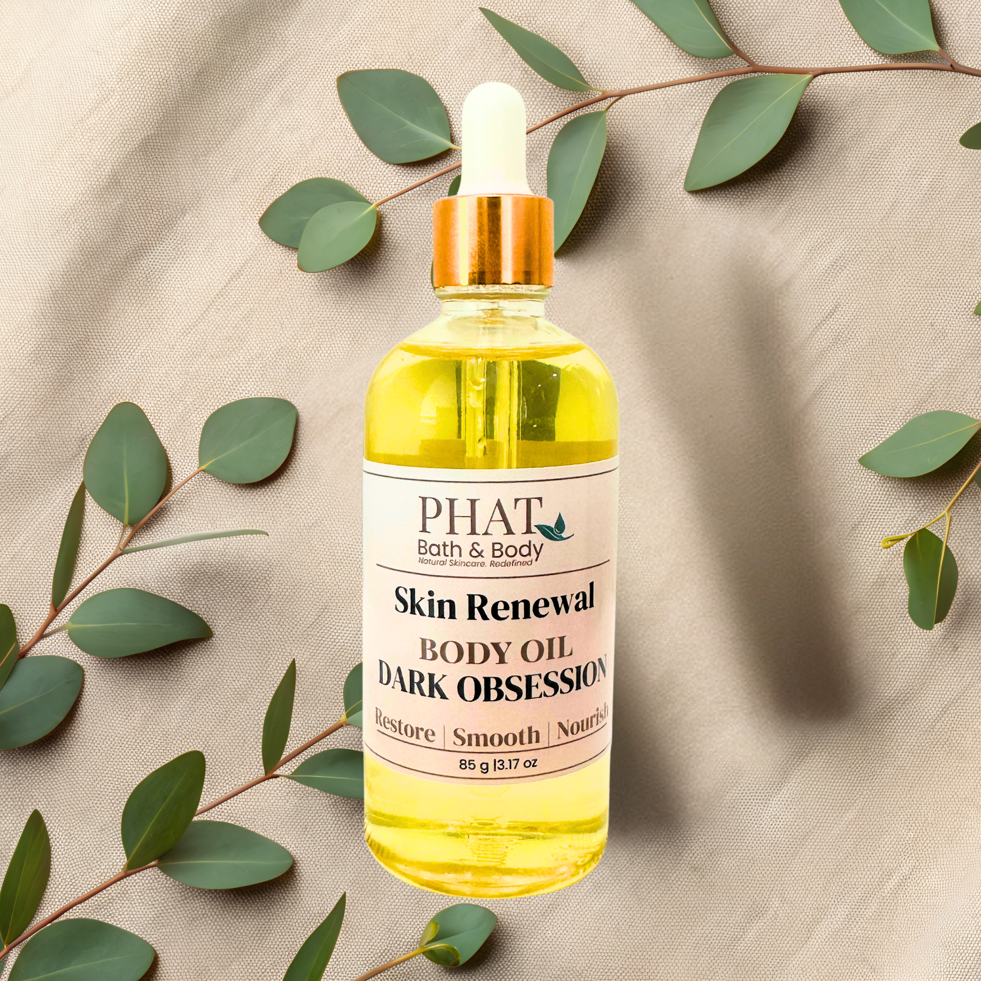 Bottle of Dark Obsession body oil from PHAT Bath & Body on a beige fabric background with green leaves.