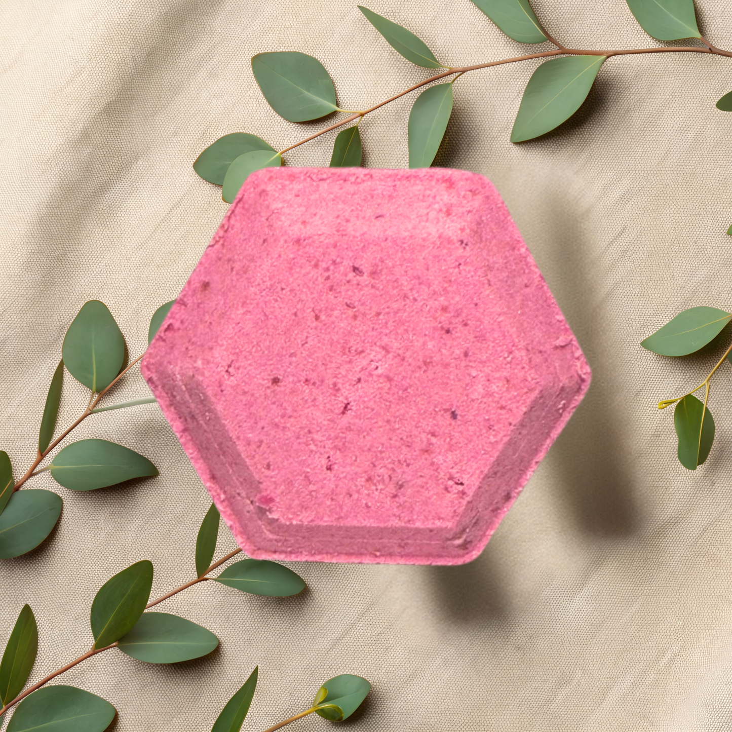 Hexagonal pink steamer with green leaves on a beige fabric background