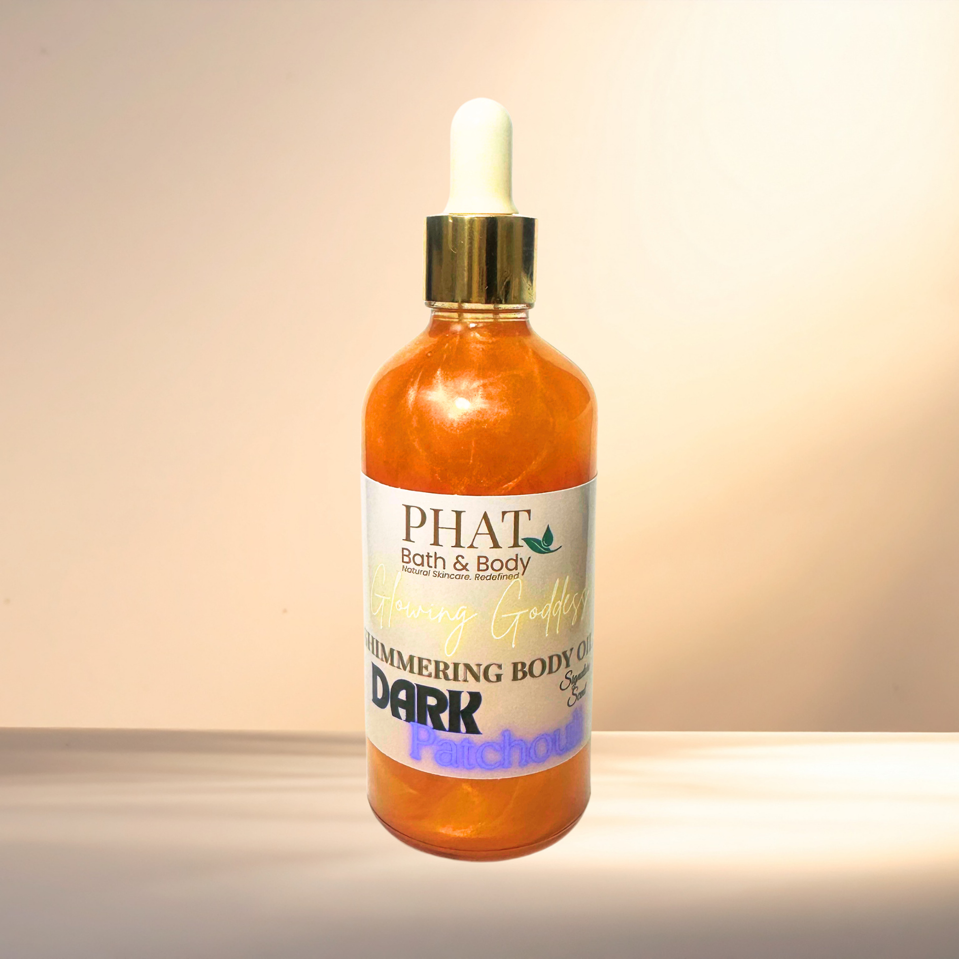 Bottle of PHAT Bath & Body shimmering body oil on a gradient background