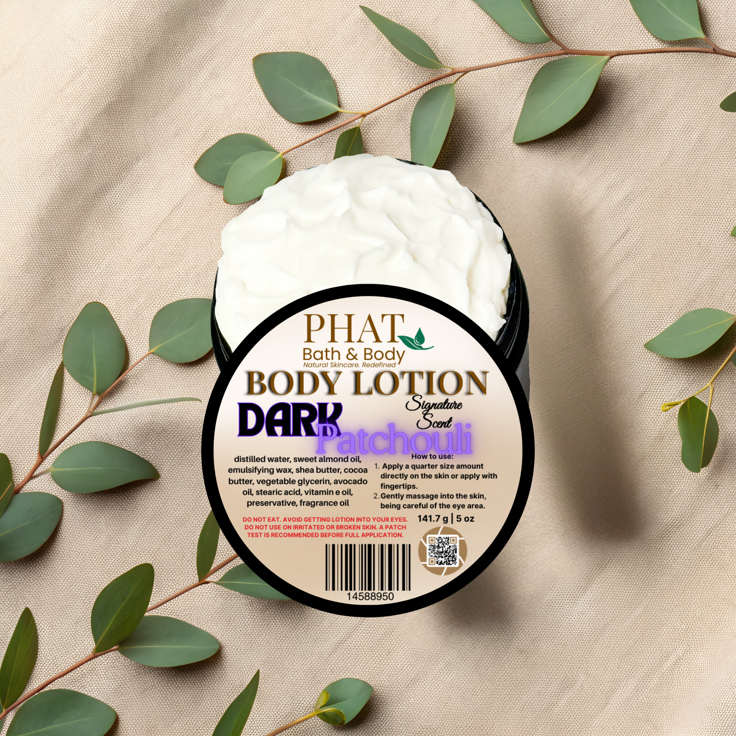 Body lotion container with 'Phat Bath & Body' label on a beige fabric background with green leaves.