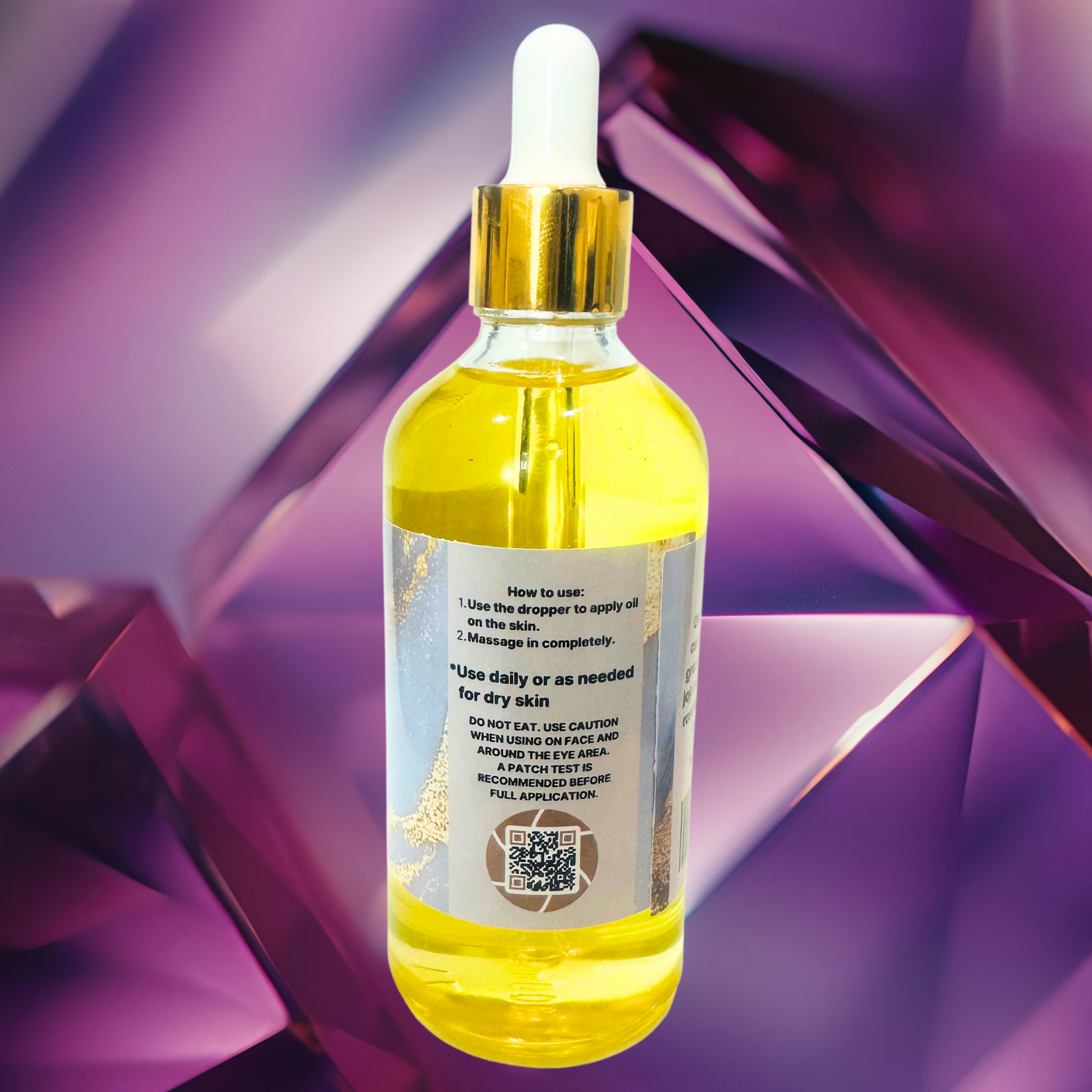 Bottle of yellow body oil with dropper on a purple geometric background