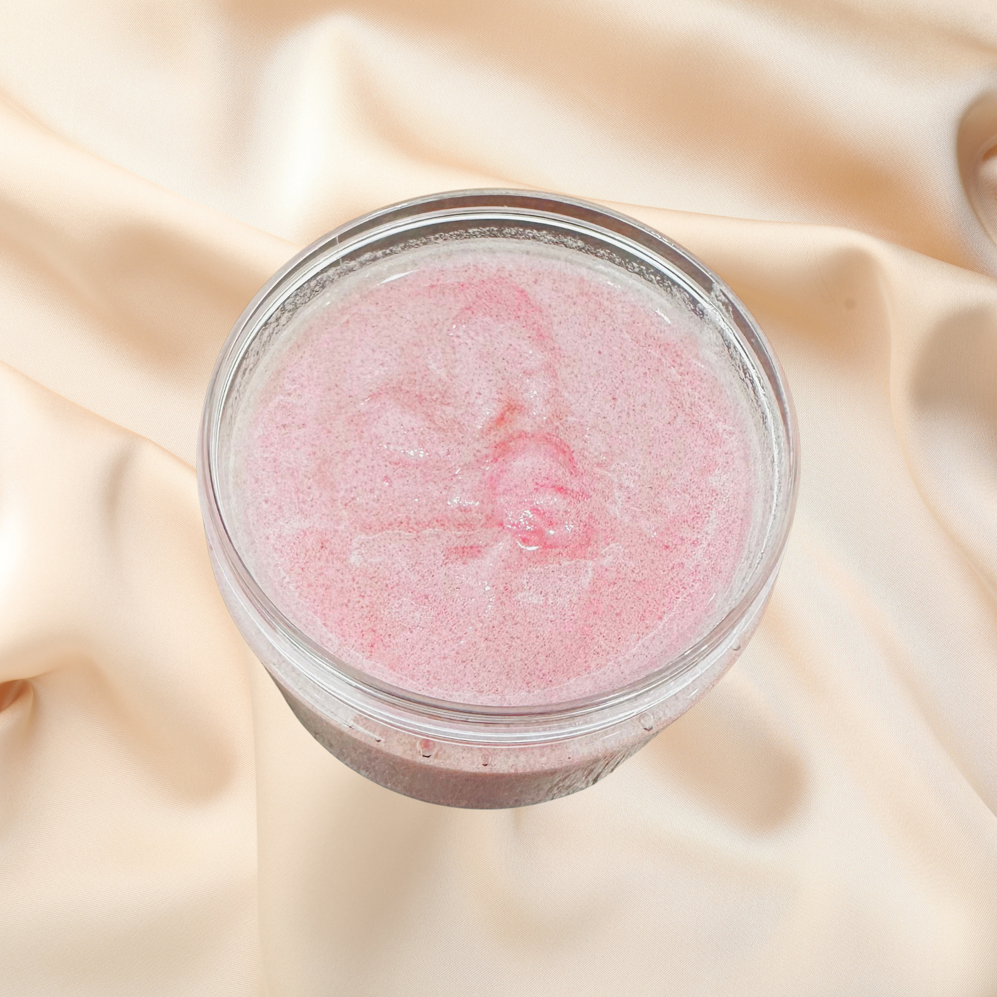Jar of pink scrub on a beige fabric background