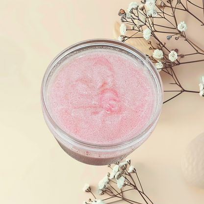 Pink scrub in a clear jar with dried flowers on a beige background