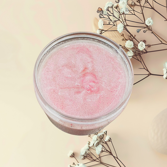 Pink scrub in a clear jar with dried flowers on a beige background