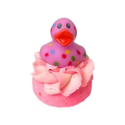Pink rubber duck with polka dots on top of a pink bath bomb with frosting.