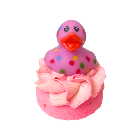 Pink rubber duck with polka dots on top of a pink bath bomb with frosting.