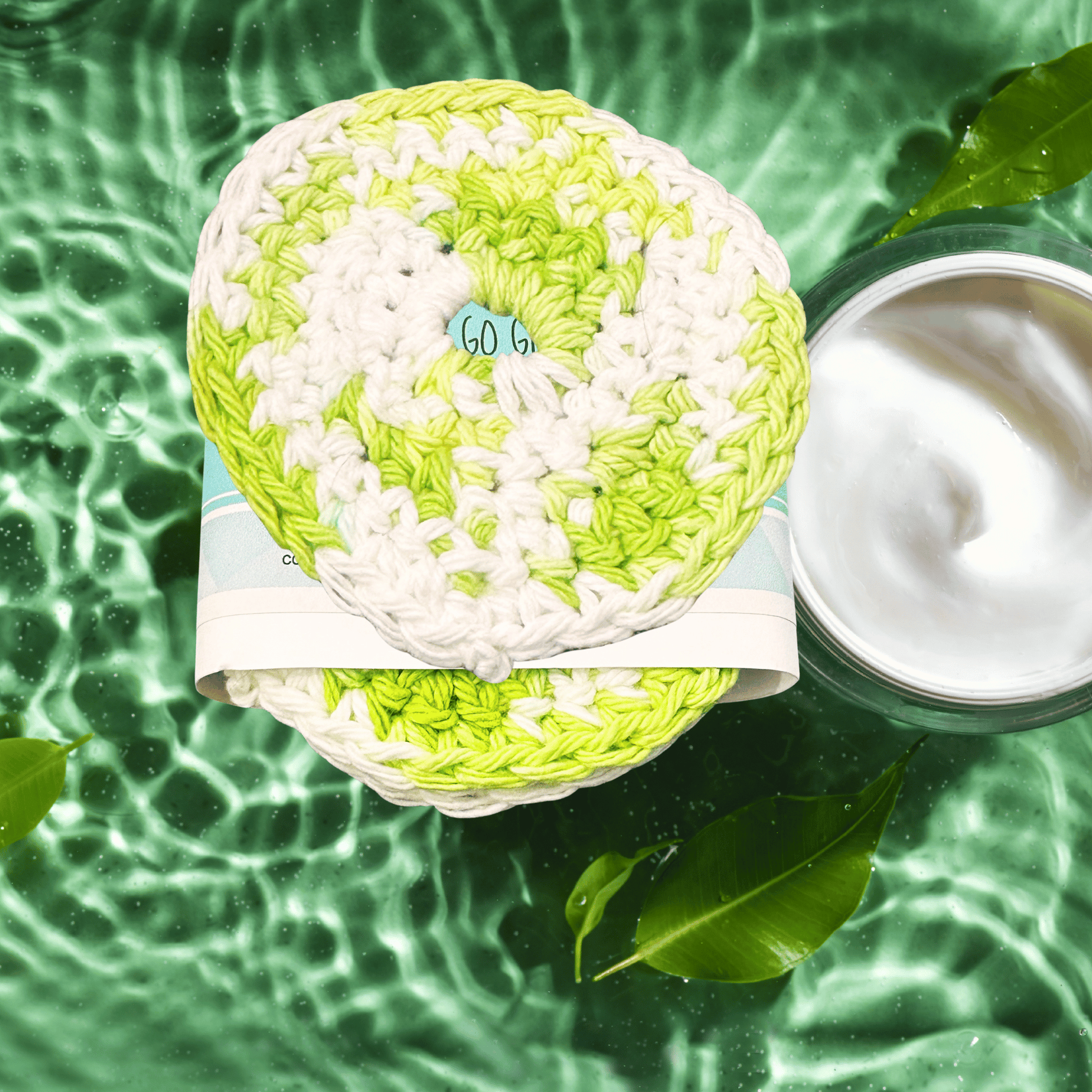 Green scrubber on a purple background with soap suds