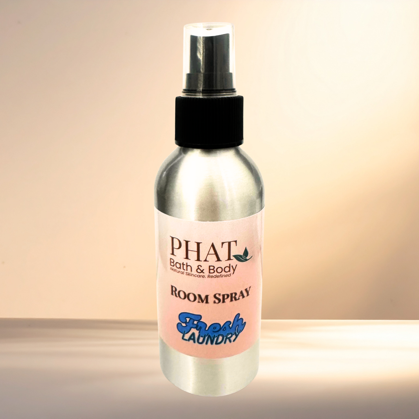 Room spray bottle labeled 'PHAT Bath & Body' with 'Fresh Laundry' scent on a gradient background
