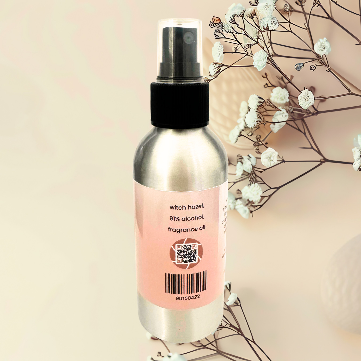 Spray bottle with a pink label on a beige background with white flowers.