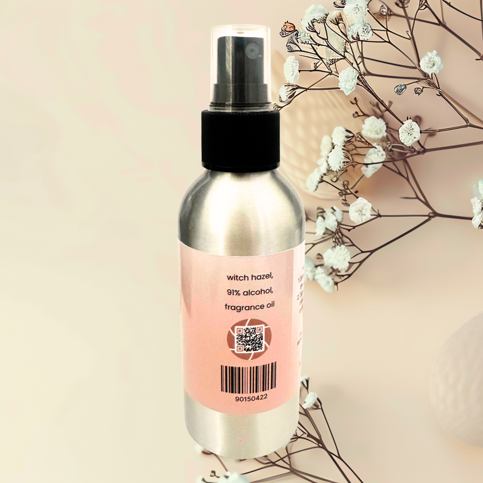 Spray bottle with a pink label on a beige background with white flowers.
