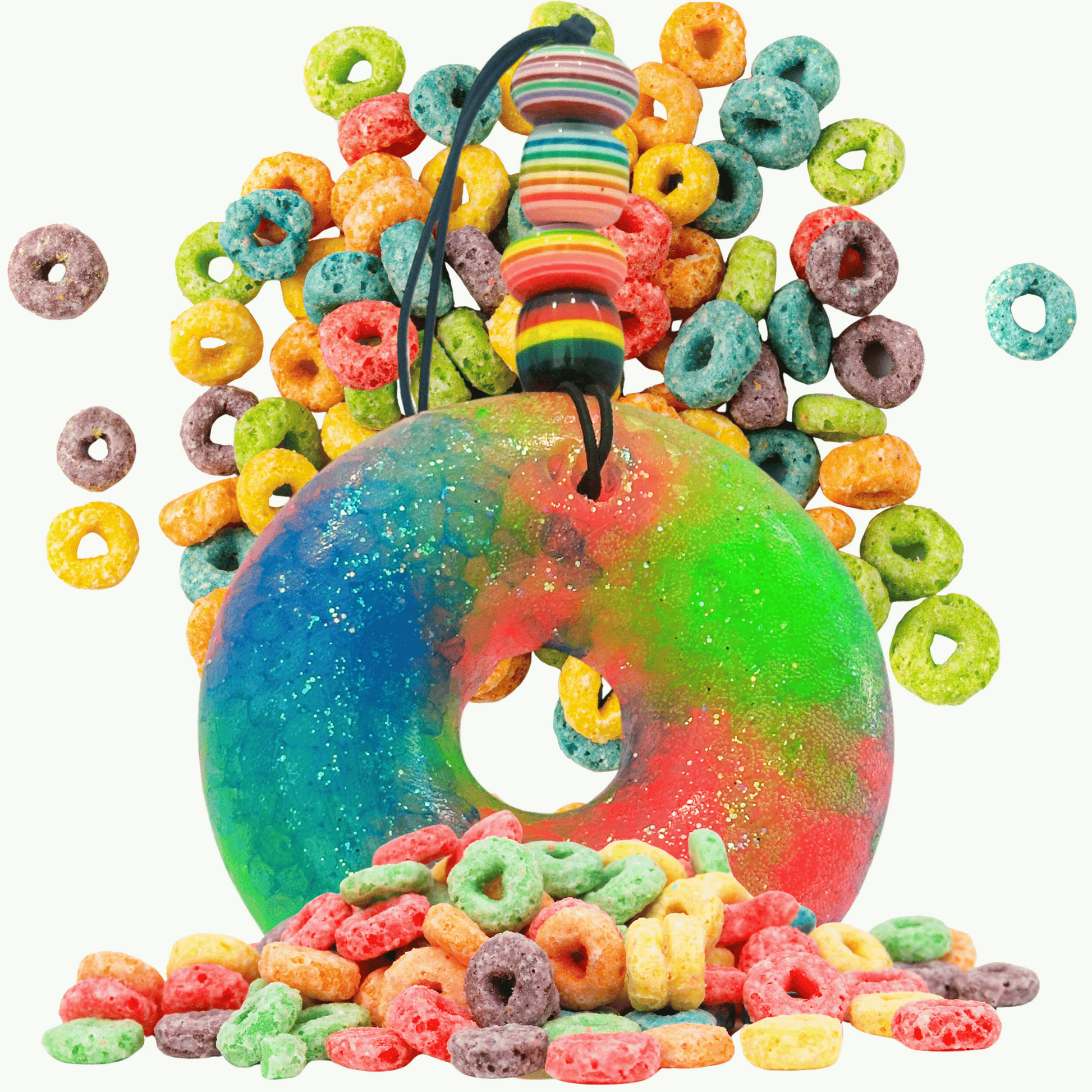 Colorful fruit loop-shaped car freshie with a string surrounded by assorted colorful cereal pieces on a white background
