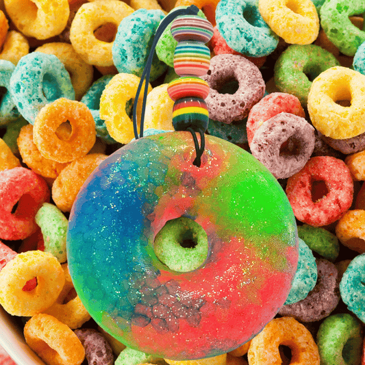 Colorful fruit loop freshie with a rainbow pattern on a background of assorted colorful cereal loops.