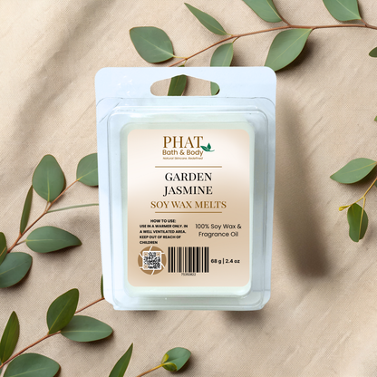 PHAT Bath & Body Garden Jasmine soy wax melts packaging on a beige fabric background with green leaves.