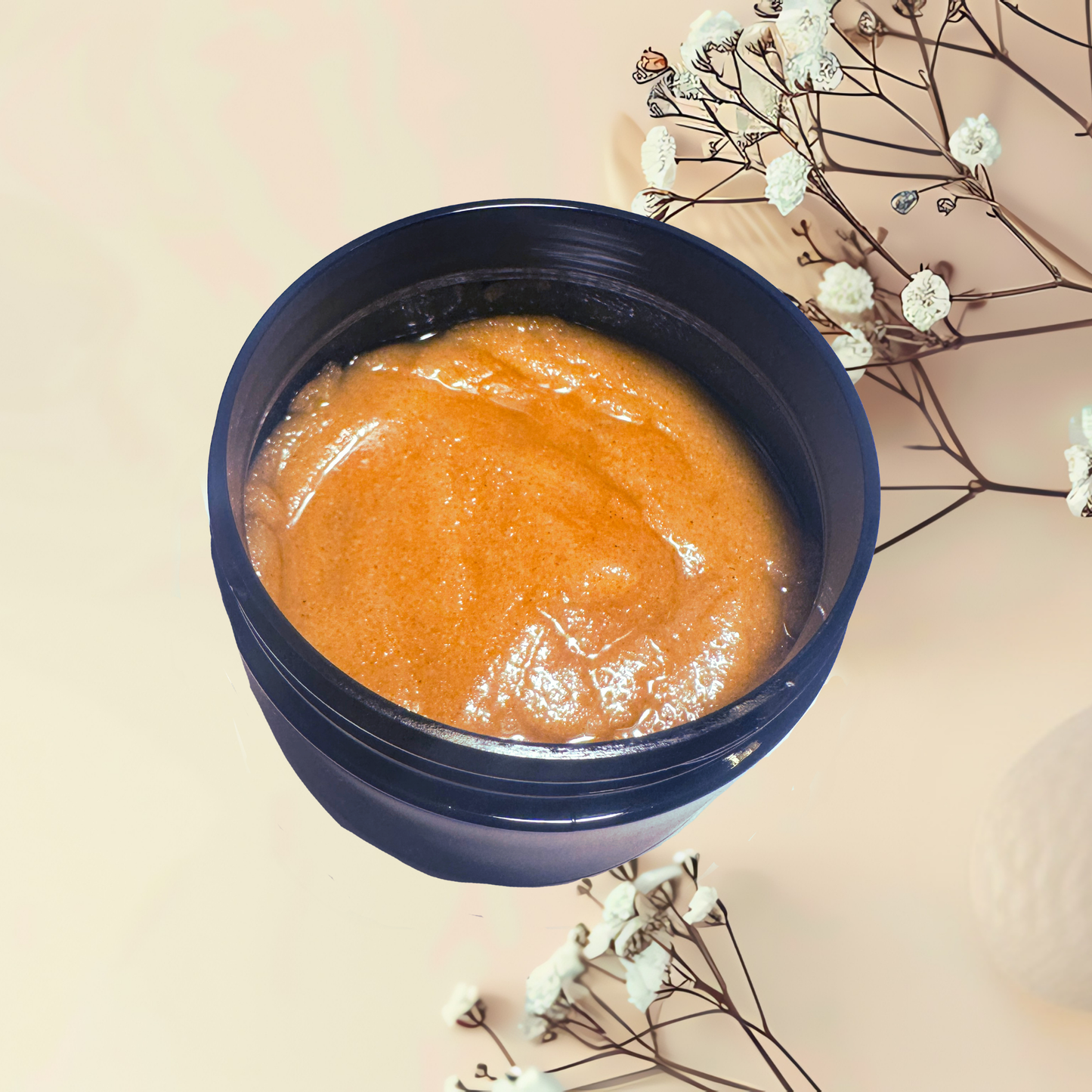 Blue container with orange scrub on a beige background with white flowers