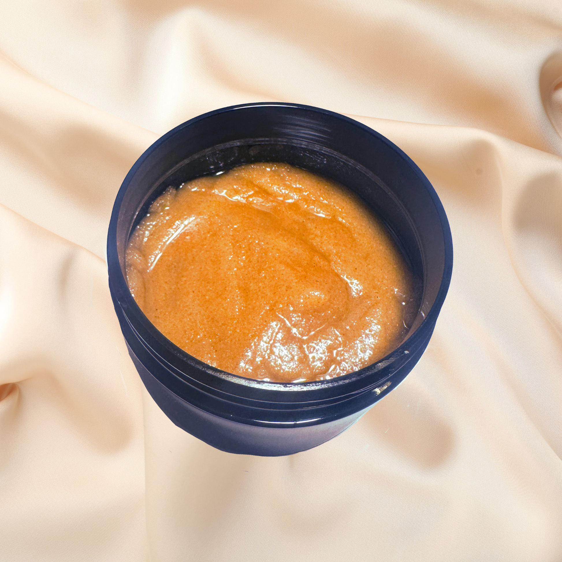 Jar of brown scrub on a beige fabric background