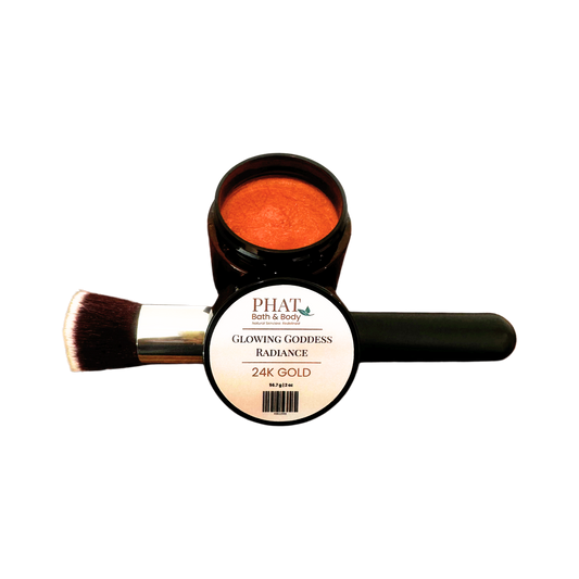 PHAT Both & Body Glowing Goddess Radiance 24K Gold body powder in a black jar with a brush resting on the side, shown against a plain white background.