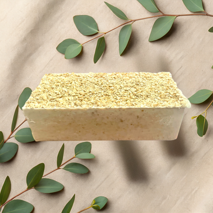 Block of soap with green leaves on a beige fabric background