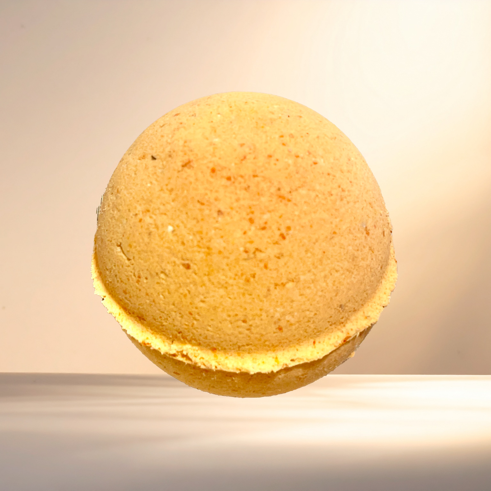 Round orange bath bomb on a neutral background