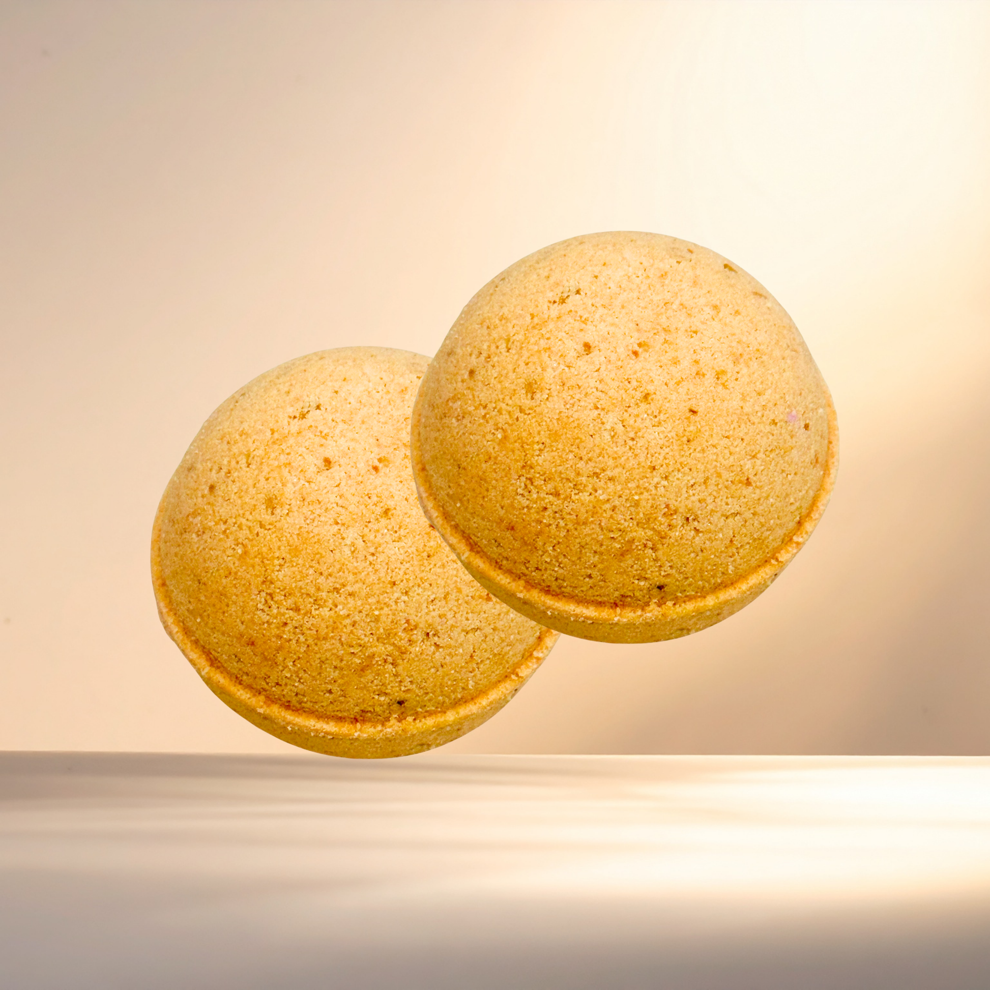 Two yellow bath bombs on a beige background