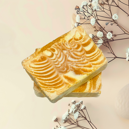 Square soap on a light pink background with white flowers.