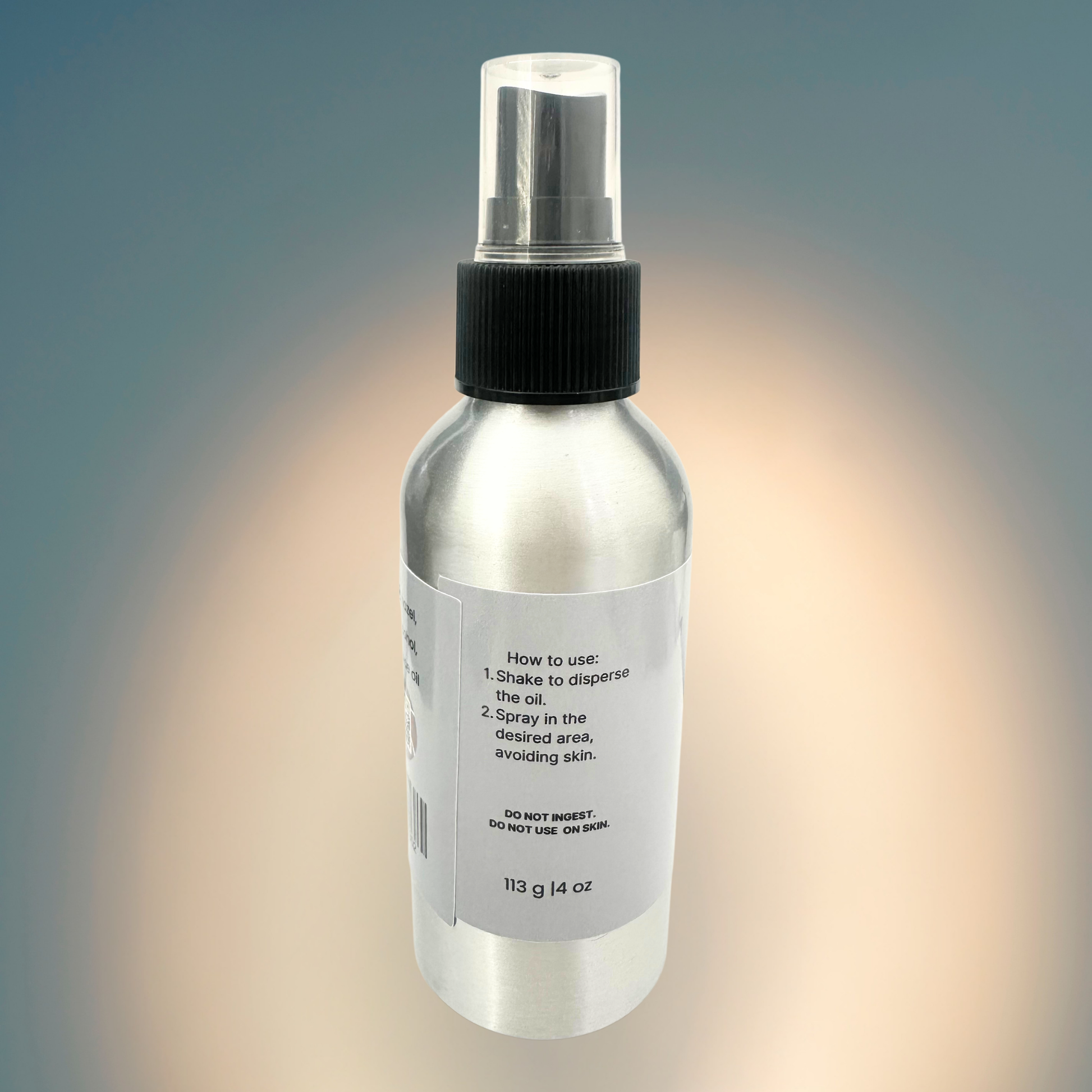Clear spray bottle with black nozzle on a gradient background