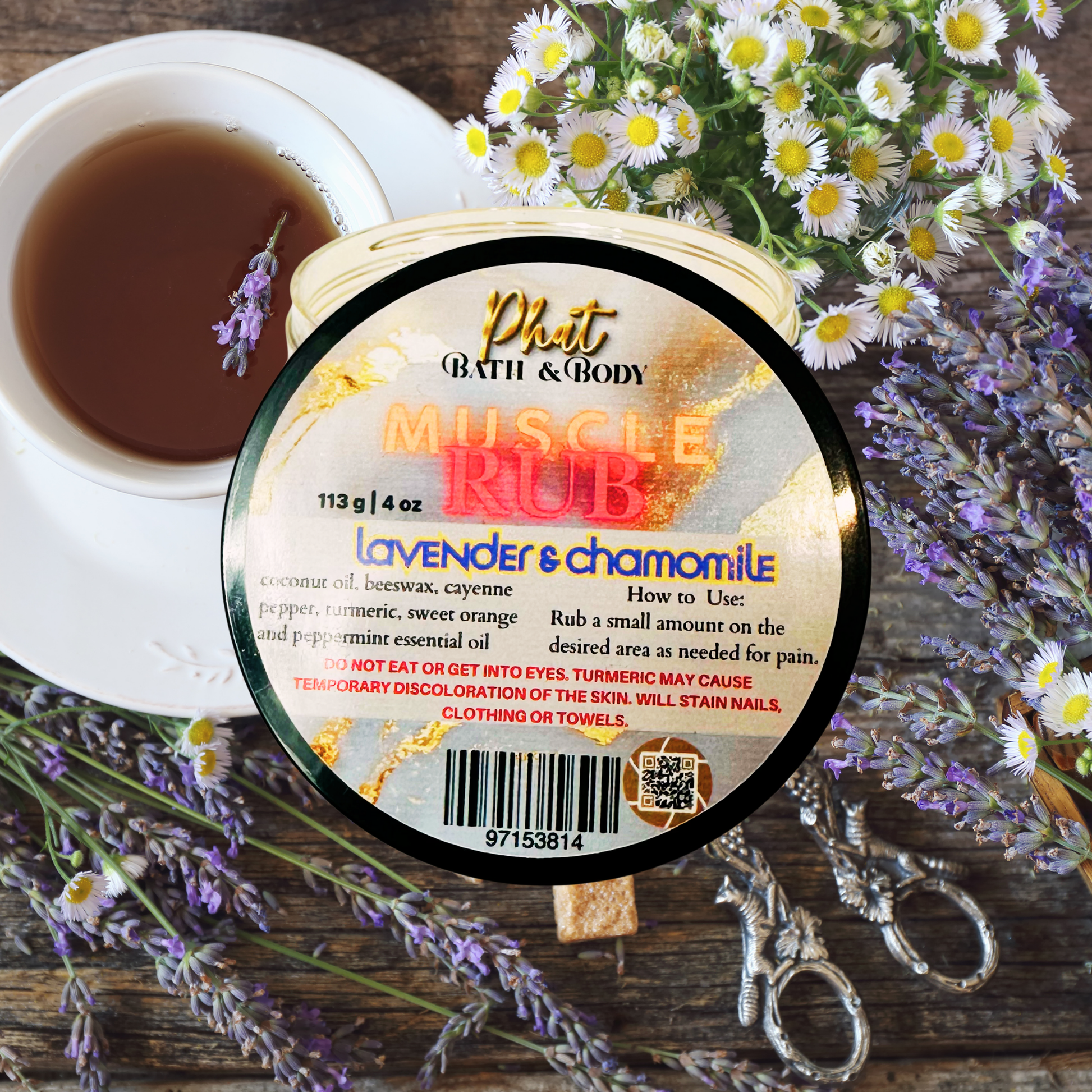 product labeled 'Muscle Rub' with lavender and chamomile on a wooden surface with flowers and tea.