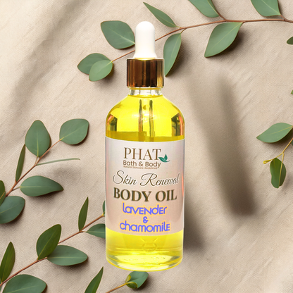 Bottle of PHAT Bath & Body Skin Renewal Body Oil with green leaves on a beige fabric background
